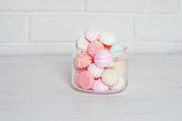 Color zephyrs in glass jar on white wooden table