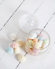 Color zephyrs in glass jar on white wooden table