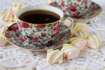  two cups of tea and marshmallow on a lace tablecloth, closeup,