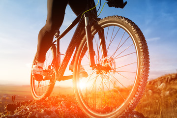 Fototapeta na wymiar Closeup of cyclist man legs riding mountain bike on outdoor trail on hill