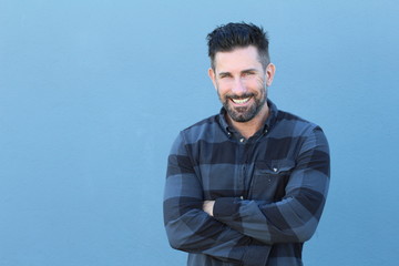 Handsome mature man smiling and laughing while crossing his arms with copy space 