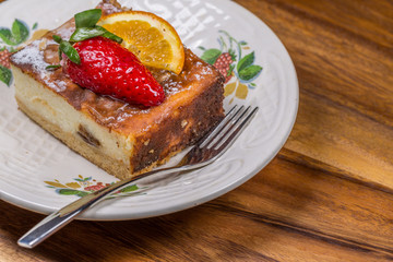 Strawberry-Lemon Cake on Saucer with fork on wooden table