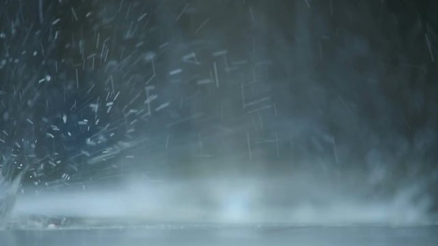 Macro Rain Drops Fall Recoil from Puddle Surface