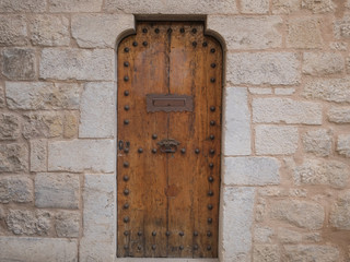 Wooden door with metal handle, stone wall