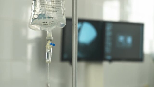 Intravenous drip, medical equipment on background. Surgeons team performing operation. 4K.