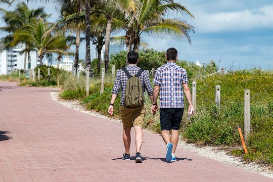 Gay Couple Walking On Miami Beach Promenade