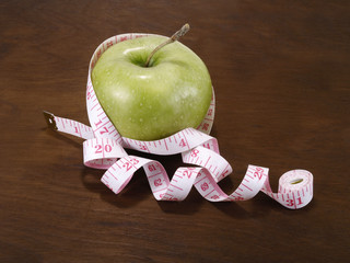 fresh green apple on a wooden table with measure