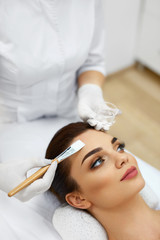 Cosmetician In Spa Salon Hydrating Beautiful Woman's Face