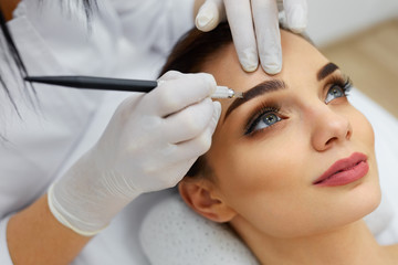 Beautician Doing Eyebrow Makeup Tattoo On Woman Using Machine - obrazy, fototapety, plakaty