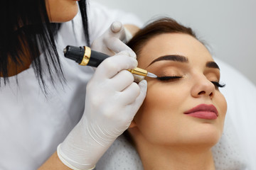 Beautician Doing Eyebrow Makeup Tattoo On Woman Using Machine - obrazy, fototapety, plakaty