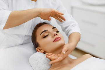 Fototapeta na wymiar Beauty Treatment. Beautiful Woman Getting Face Head Massage