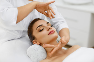 Fototapeta na wymiar Beauty Treatment. Beautiful Woman Getting Face Head Massage