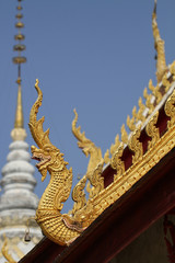 Fototapeta na wymiar close-up ancient golden colorful dragon horse statue on side of roof top at Thailand national north landmark temple