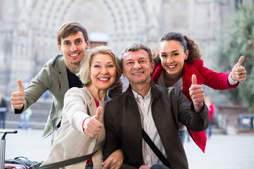 Close up of tourists posing on city street.