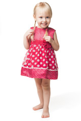 Cute smiling little girl in red dress posing at studio