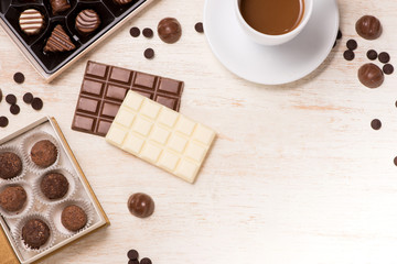 Chocolate balls, coffee cup and coffee cup on table.