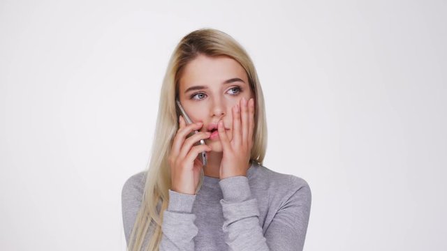 Young Pretty Woman in gray sweater which talking on phone