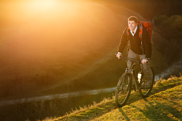 Mountain biker riding on bike in spring inspirational mountains landscape. inspiration outdoors in sunset.