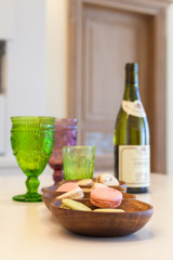 Dessert, wine and glasses of colored glass on a table made of wood