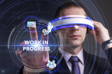 Business, Technology, Internet and network concept. Young businessman working in virtual reality glasses sees the inscription: Work in progress