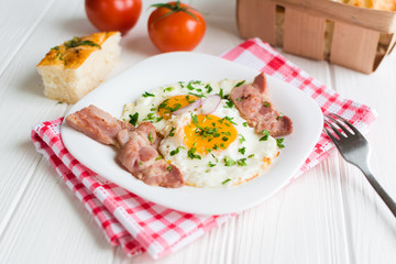 Fried eggs with bacon on white background