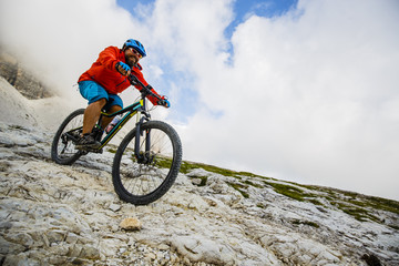 View of cyclist riding mountain bike on trail in Dolomites,Tre Cime di Laverado, South Tirol, Italy