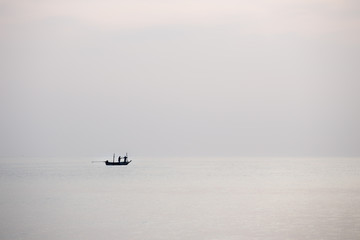 silhouette minimalist of single  fishery boat float on calm sea