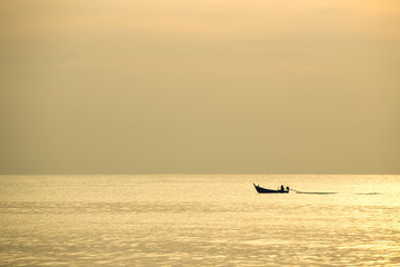 Fototapeta premium silhouette minimalist of single fishery boat sail on calm sea in sunrise