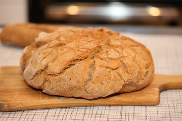 Black round homemade bread on the cutting board.