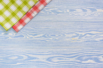 Red and green towel over wooden kitchen table. View from above with copy space