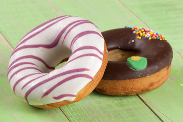 two glazed donut on wooden green background