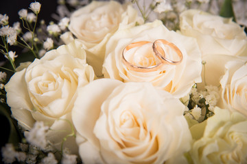 Wedding rings on a bouquet of white roses