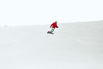 Naklejka na ściany i meble Man in red ski suit executes a heel-side turn