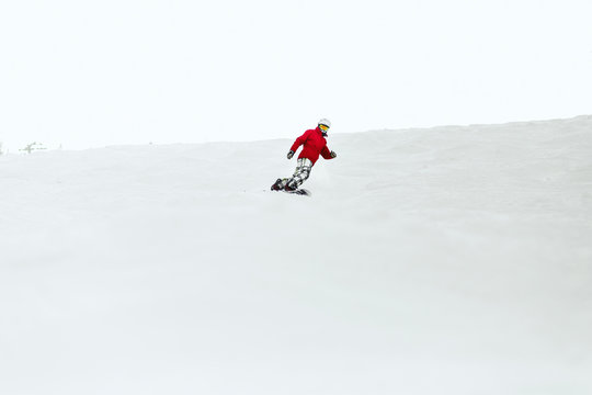 Man in red ski suit executes a heel-side turn