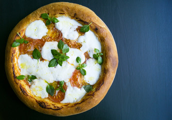 pizza Margarita on a black background. space to the right