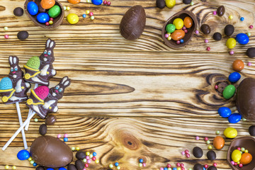 Chocolate Easter eggs over rustic wooden background. Copy space