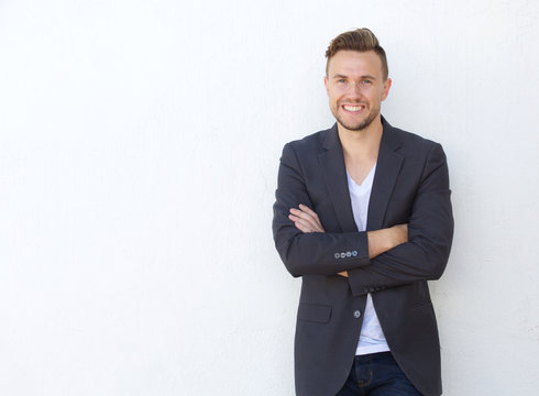 attractive young businessman smiling against white wall