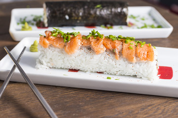 Delicious sushi rolls on wooden background