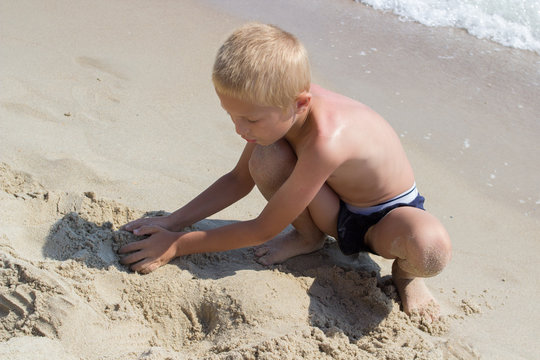blonde boy playing on the beach