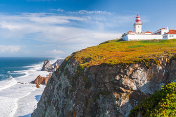 Fototapeta na wymiar The lighthouse in Cabo da Roca. Cliffs and rocks on the Atlantic ocean coast in Sintra in a beautiful summer day, Portugal