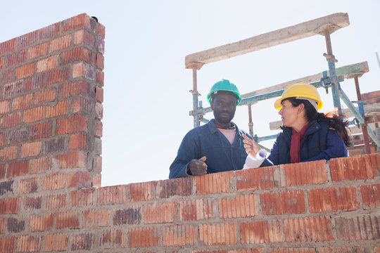 Woman and builder talking on construction site