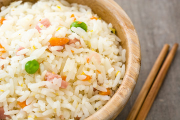 Fried chinese rice with vegetables on wooden table
