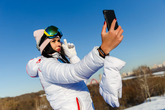 Beautiful brunette snowboarder photographing herselves