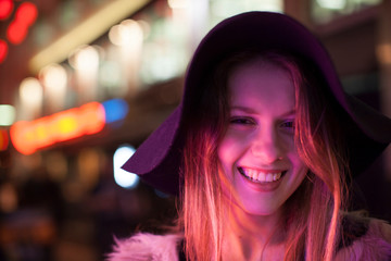 Young woman enjoying bright neon lights of street, London, UK
