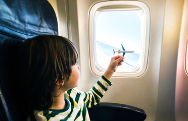 Boy playing toy plane during flight