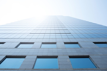 Clouds reflected and sunlight in windows of modern office building. 