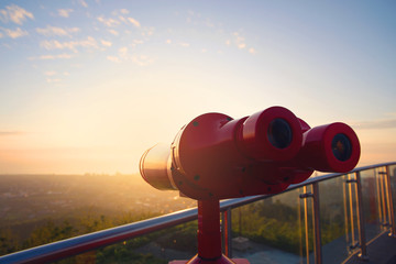 Tourist binoculars for watching cityscape in the sunset colours. - 137239843