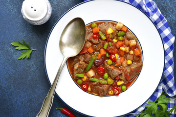 Mexican style veal stewed with vegetables in tomato sauce  .Top view with space for text.