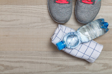 Fitness gym equipment. Sneakers, water bottle with towel. Workout footwear. Sport trainers with pink shoelace.