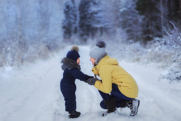 Little boy with mother outdoor. Winter. Sled..